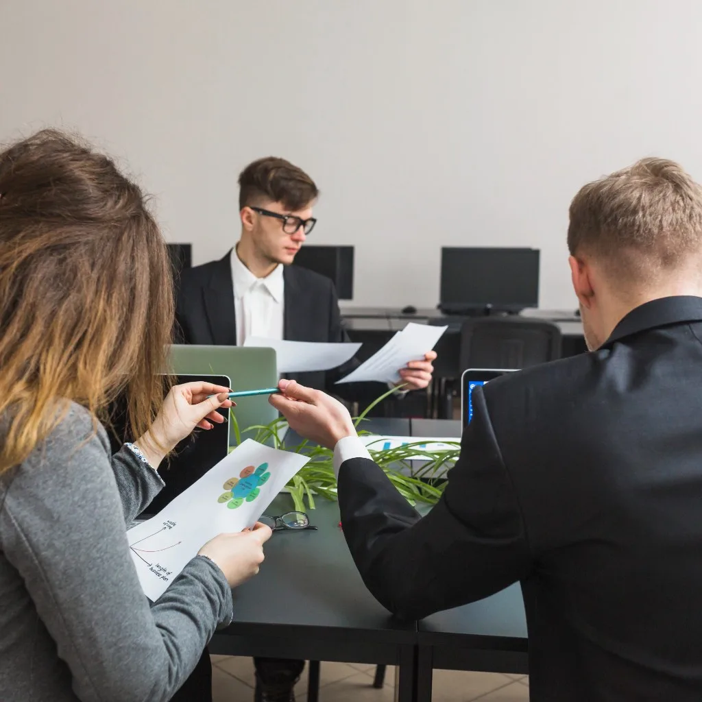 Business professionals collaborating on recruiting and workforce planning documents in a modern office